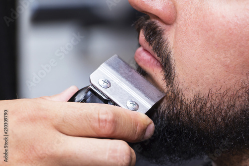 Beard styling and cut. Close up cropped photo of a styling of a red beard. Advertising and barber shop concept.