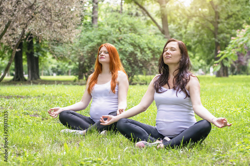 Pregnant young women doing prenatal yoga. Meditation