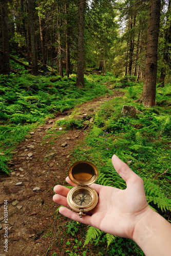 Female hand holding compass