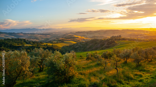 Idyllic evening sunset in Tuscan landscape with green hills, Tuscany, Italy.