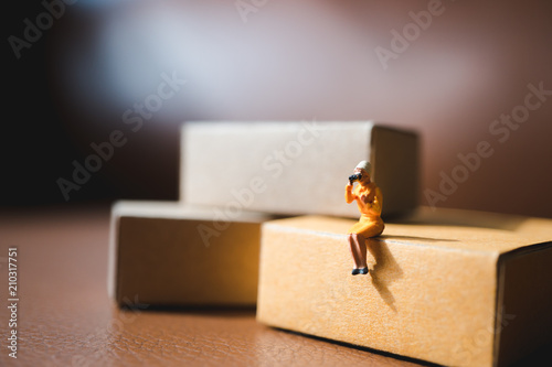 Miniature people,woman sitting on paper box using as business and human resource concept