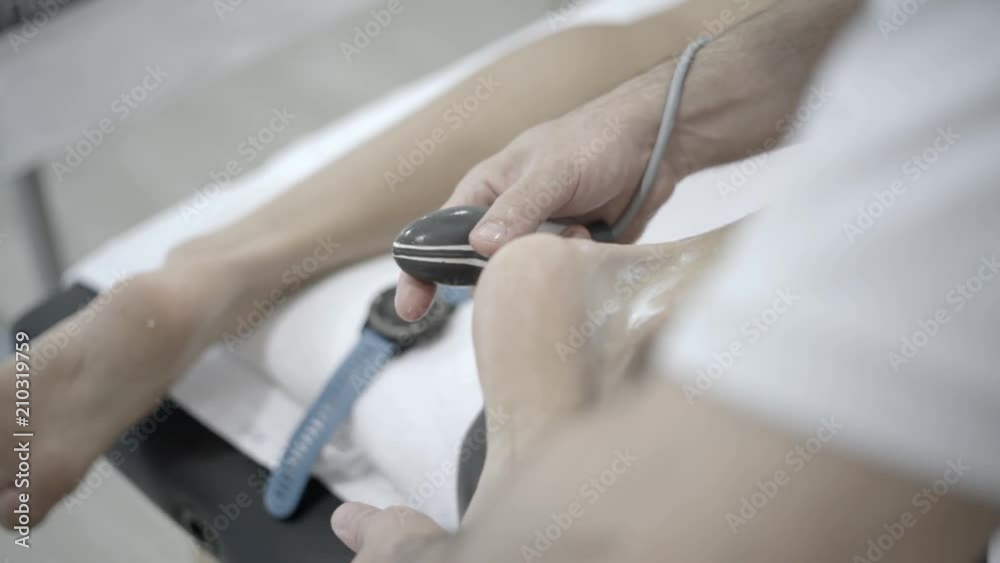 The physiotherapist treating a man using equipment for radio therapy The physiotherapist treating a man using equipment for radio therapy