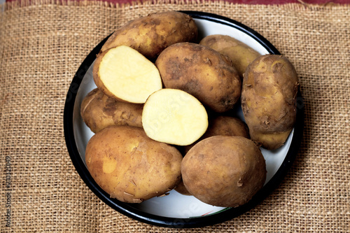 Raw young organic potatoes, full and half