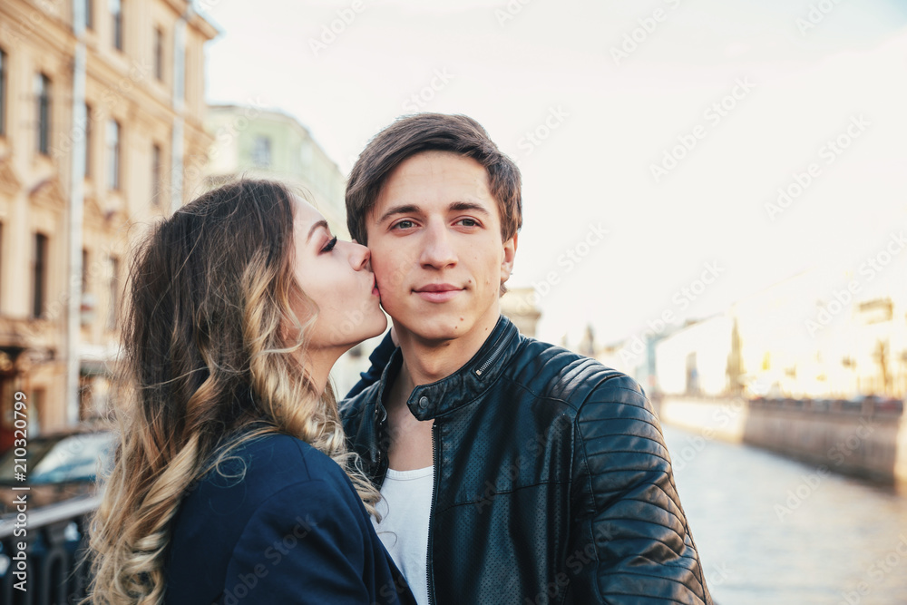 Happy couple is spending vacation holidays in St. Petersburg. Both look really happy. They are strolling along the streets of the old town Happy couple is spending vacation holidays in St. Petersburg. Both look really happy. They are strolling along the streets of the old town