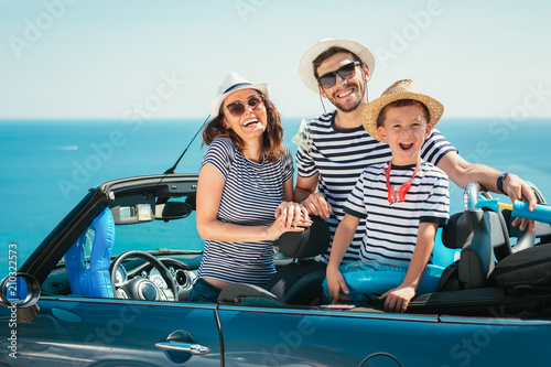 Happy family travel by car to the sea. People having fun in cabriolet. Summer vacation concept