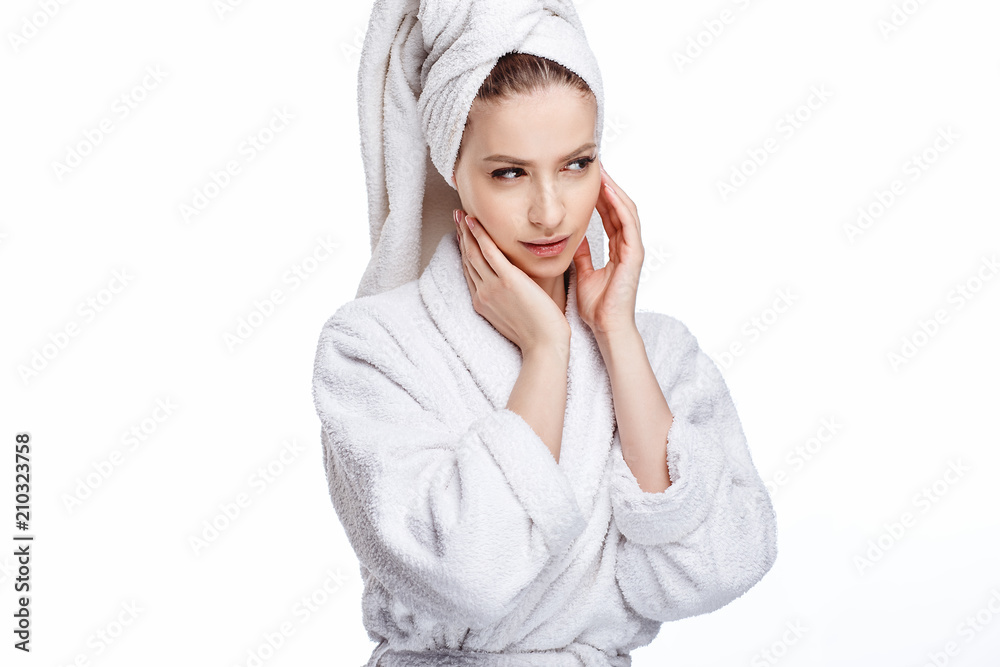 Young woman in a bathrobe and towel on her head, spa and care portrait, clean natural face, portrait on a white background isolated
