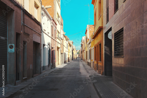 A narrow colorful street in a small town in the suburbs of Barcelona.