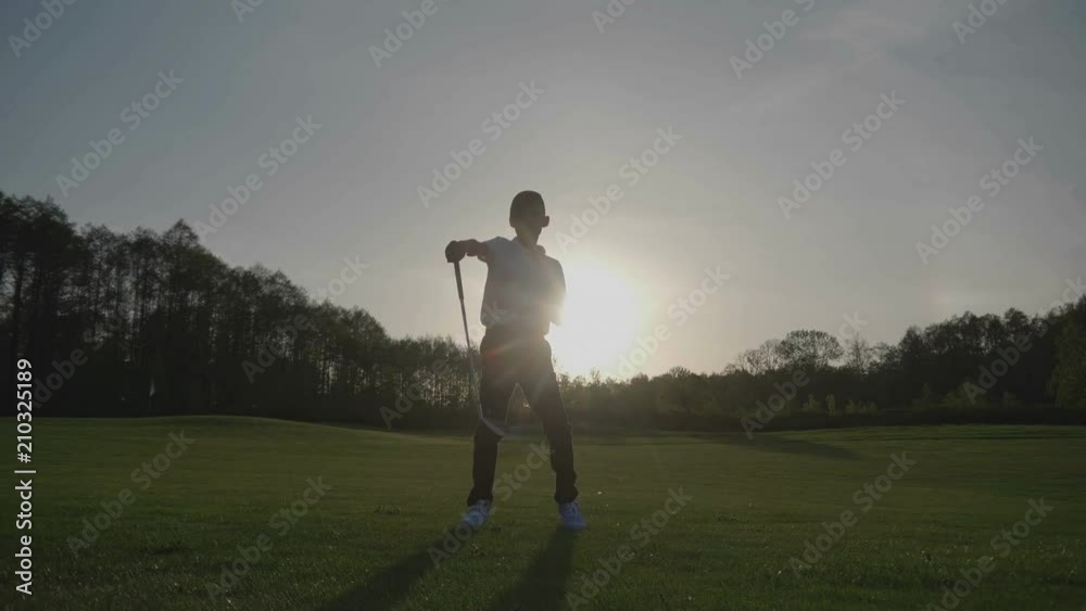 Silhouette Junior Golfing Into Sunset. Silhouette Junior Golfing Into Sunset.