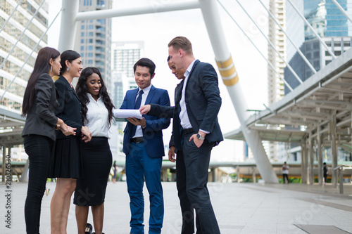 business people standing in the city and discussing ideas for business future. multi culture of business people, African, Caucasian and Asian.
