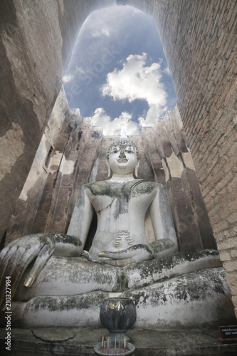 Ancient marvellous stone buddha statue surrounding by great wall and attractive blue sky at Wat Sri Chum, Sukhothai, Thailand, smilling peace buddism location , travel destination backgrounds,