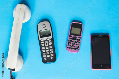 Technology evolution concept, old and new telephones on the blue background.