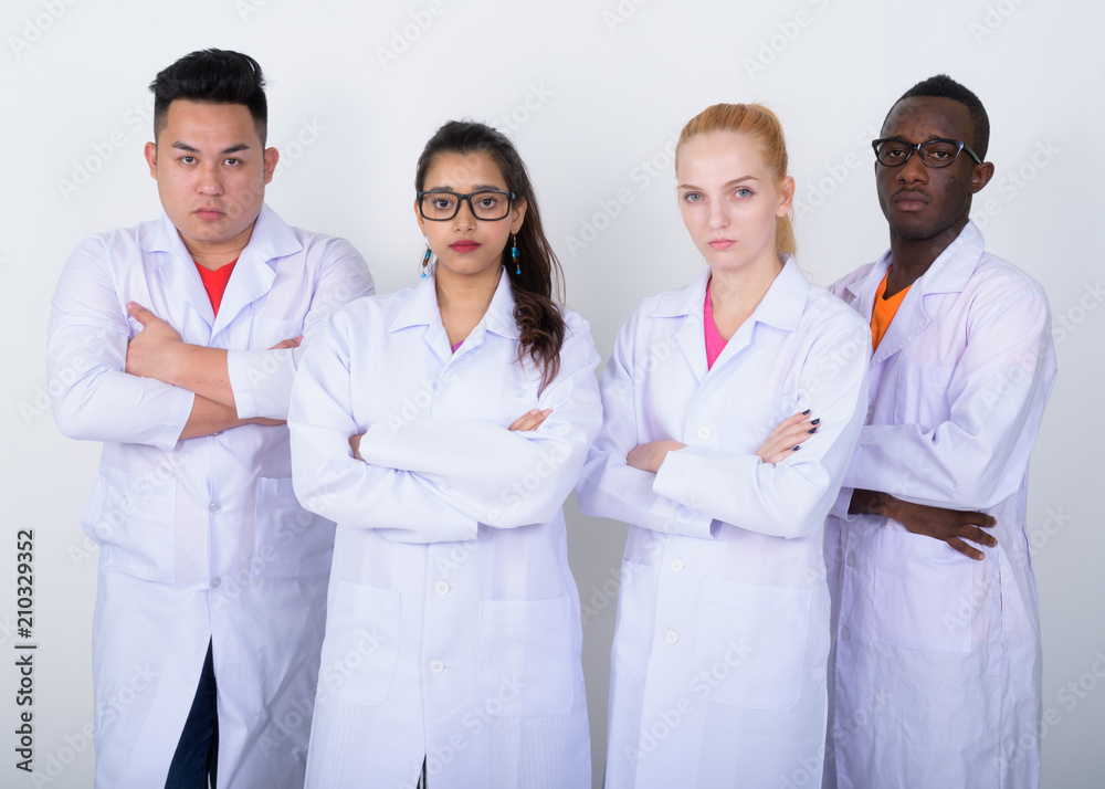 Studio shot of diverse group of multi ethnic doctors with arms c
