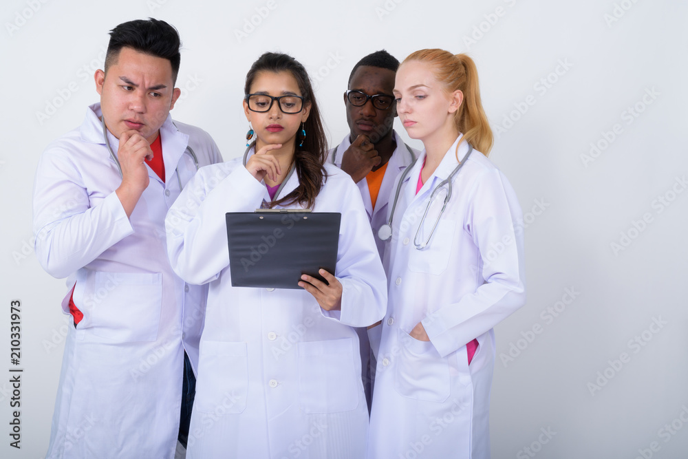 Studio shot of diverse group of multi ethnic doctors thinking wh Studio shot of diverse group of multi ethnic doctors thinking wh