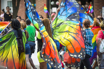 Gay pride carnival parade participants wearing colorful rainbow butterfly wing costumes in Greenwich Village