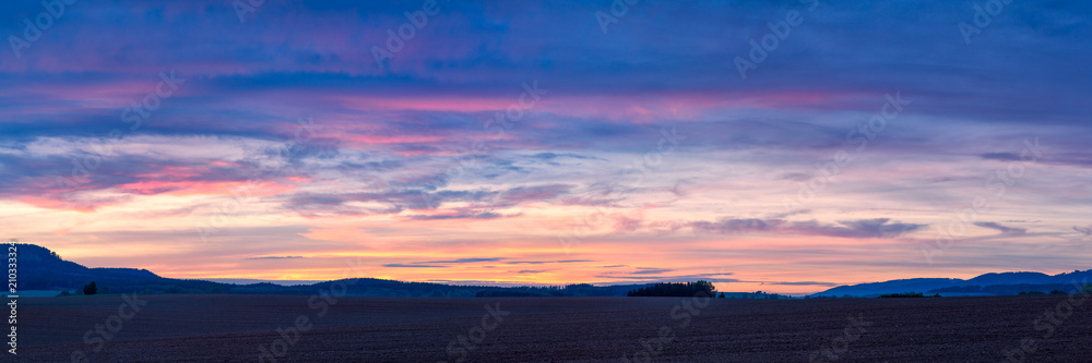 Colorful sunset over plowed fields in Northern Bohemia in the Czech Republic, Europe