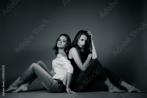 Two pretty girls in hipster clothes, sitting