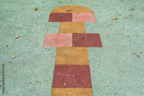 Children's game of cork hopscotch on the ground of a park