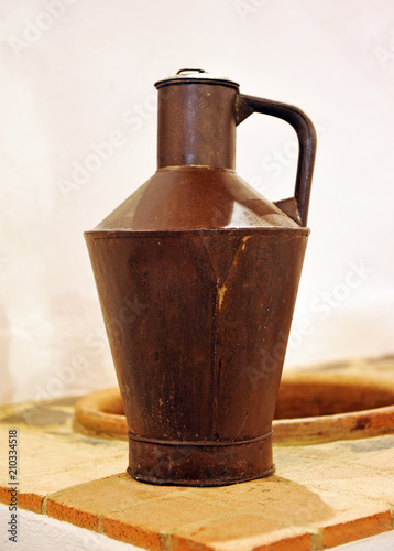 Old pitcher for olive oil in rusty metal sheet, Andalusia, Spain photo