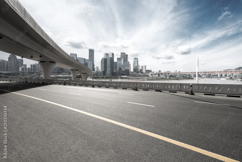 Fototapeta premium asphalt road with city skyline