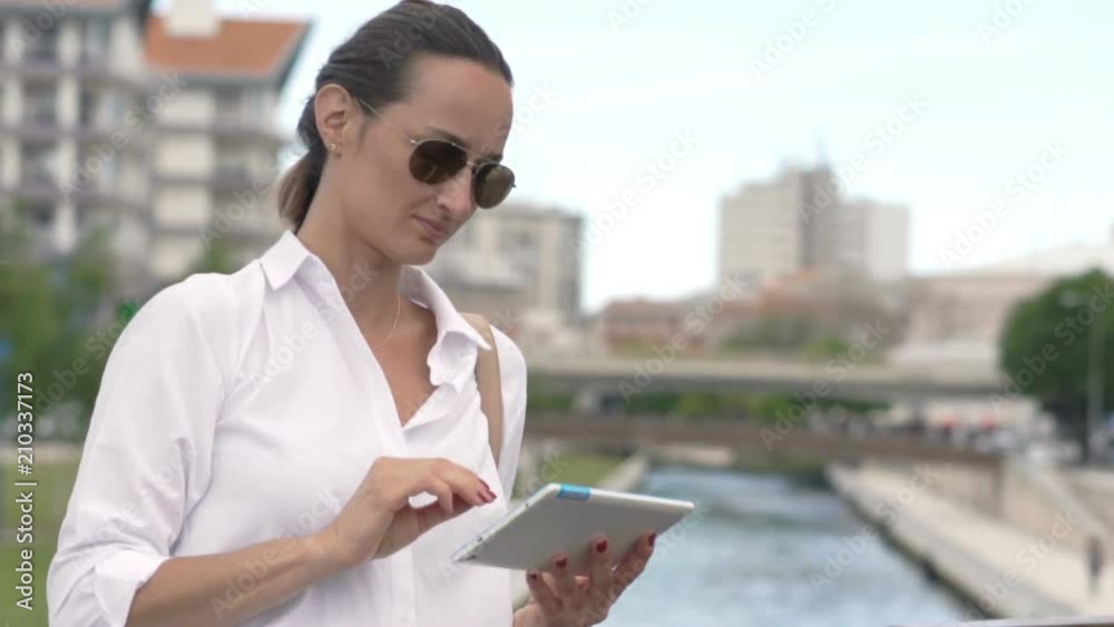 Young woman using tablet computer standing on bridge in city
Young woman using tablet computer standing on bridge in city