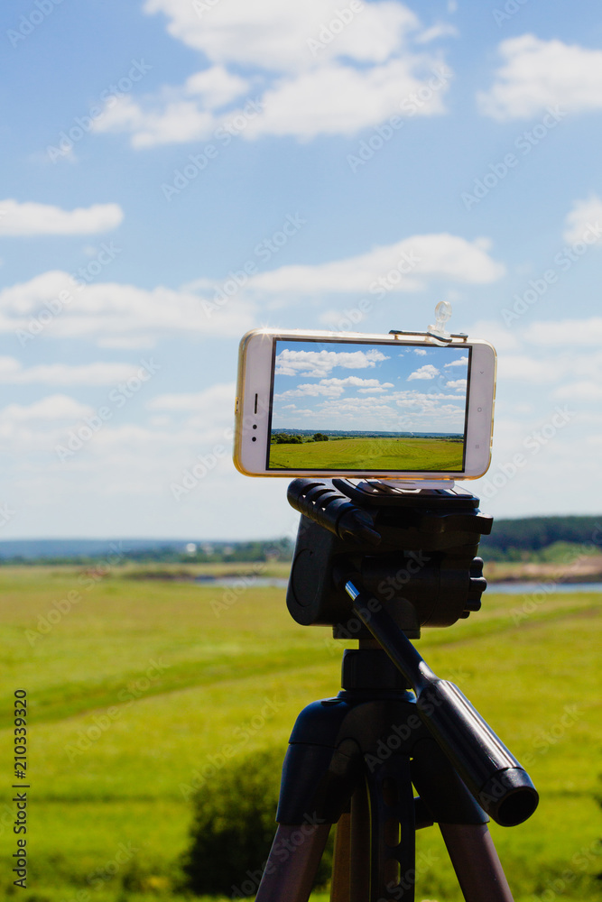 Smartphone on tripod capturing summer landscape Smartphone on tripod capturing summer landscape