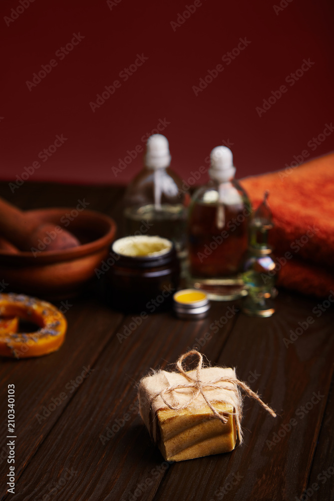 Fototapeta premium Bar of handmade soap on dark wood background. Natural cosmetic oil, cream, and natural handmade wax with lavender on dark background. Healthy skin care. Aromatherapy, spa and wellness concept