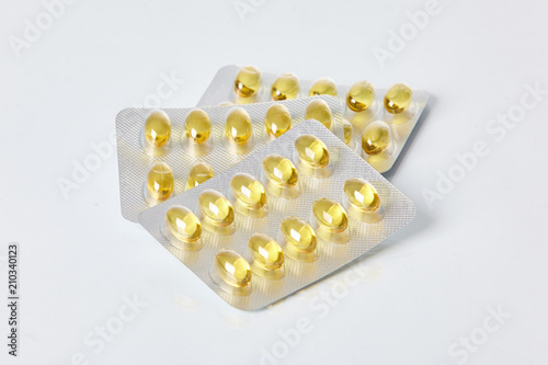 Fish oil gelatine capsules on white background. Health care concept. Pack of pills. 