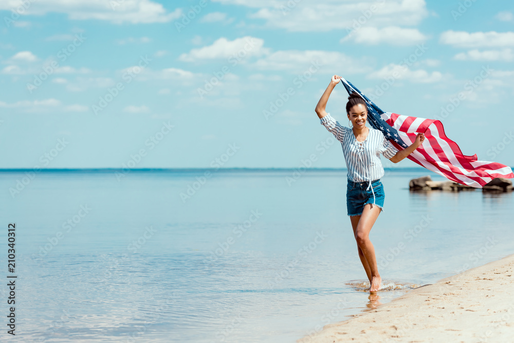 happy woman running in sea water with american flag, independence day concept happy woman running in sea water with american flag, independence day concept