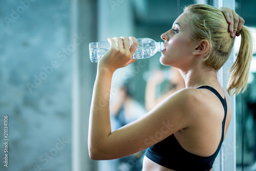 attractive caucasian woman relax with pure water after workout with happiness and joyful in gym healthy ideas concept