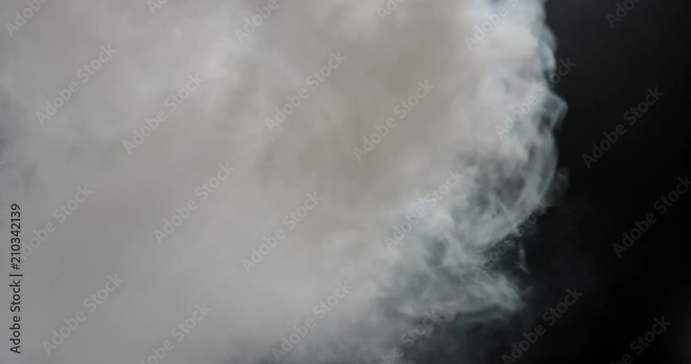Dense cloud of thick cotton smoke filling frame with turbulence on the side Dense cloud of thick cotton smoke filling frame with turbulence on the side