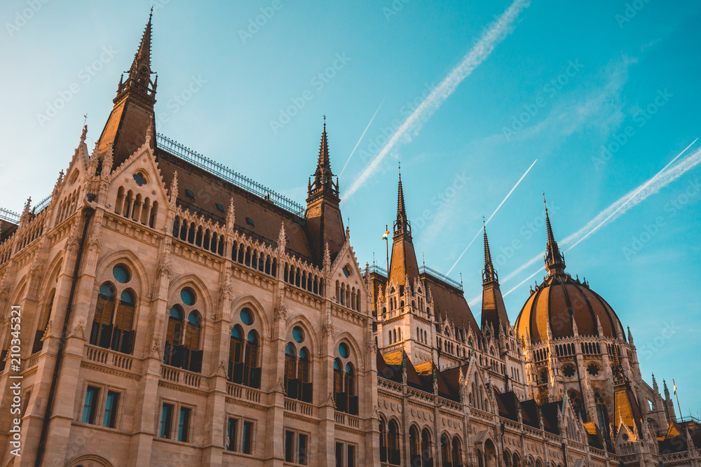 low angle view of parliament building at budapest with big contrails in the sky