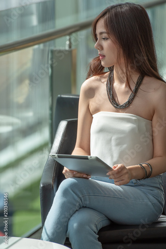 Portrait young happy woman working on laptop computer in the modern style office building.