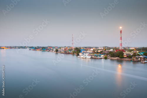 Fisherman village beside river with moon reflection in early morning located thai gulf of thailand