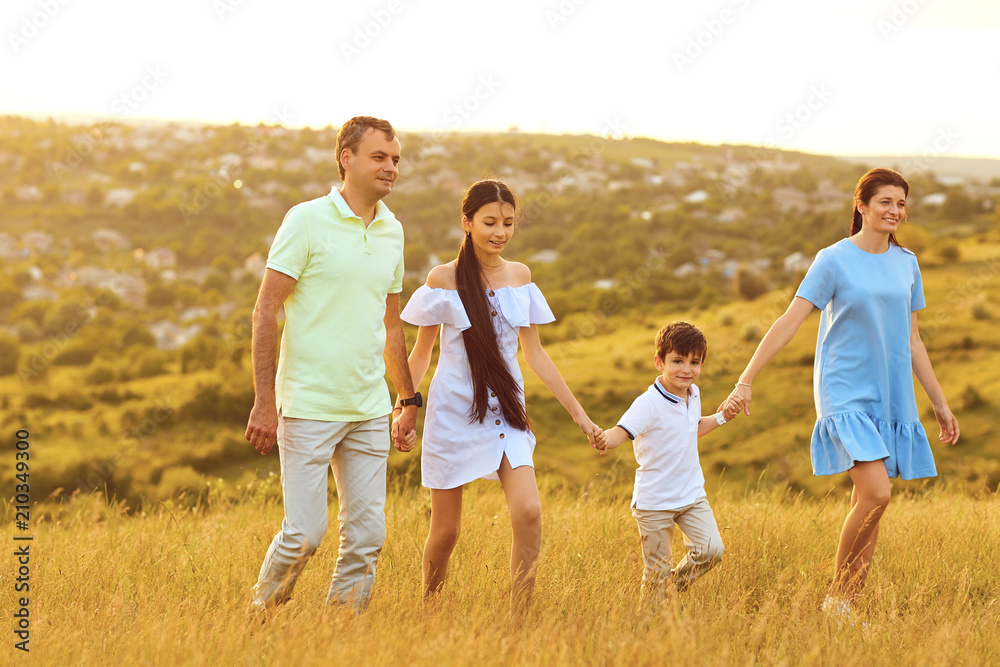 Happy family is having fun around the field at sunset. Family in nature. Happy family is having fun around the field at sunset. Family in nature.