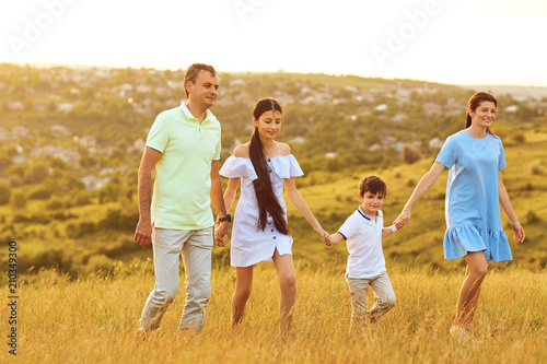 Happy family is having fun around the field at sunset. Family in nature.