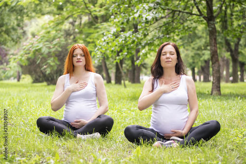 Pregnant young women doing prenatal yoga.
