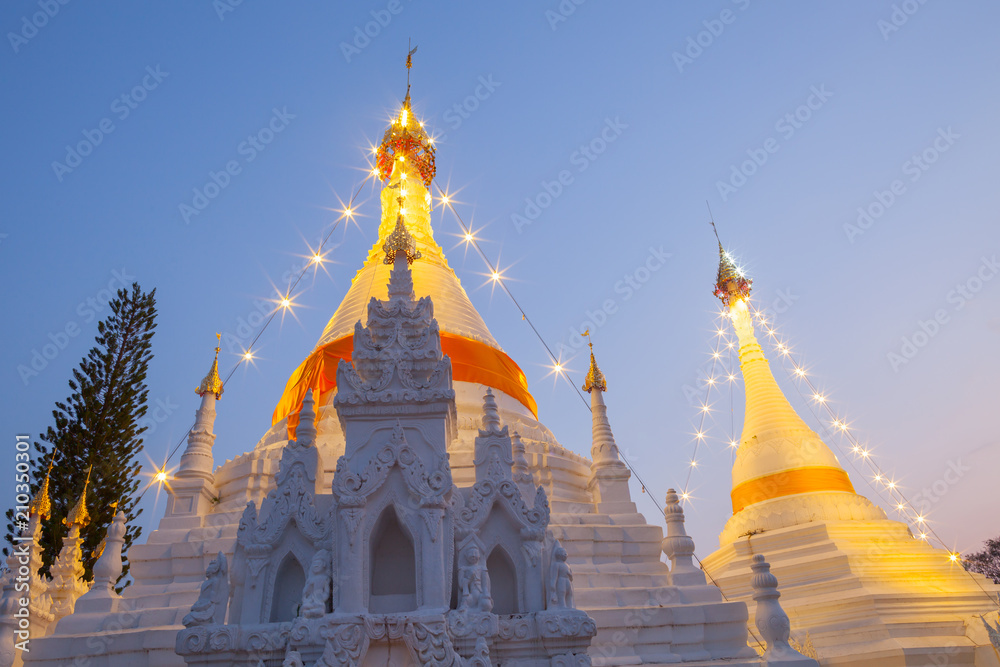Naklejka premium A white color of pagoda decorated by lighting at night time under clear sky located at north of Thailand