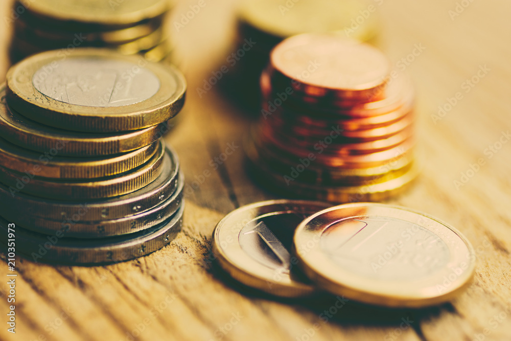 Stacks of Glossy White and Yellow Euro Coins of Different Value on Wood Background. Finances Investment Stocks Savings Budget Concept. Warm Matte Tones. Poster with Copy Space Stacks of Glossy White and Yellow Euro Coins of Different Value on Wood Background. Finances Investment Stocks Savings Budget Concept. Warm Matte Tones. Poster with Copy Space