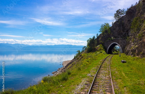 Old stone arch tunnel in mountain the rock on the Circum-Baikal railway. Idyllic  background of a summer landscape with mountains and lake Baikal for transfer of an aura of wanderlust photo