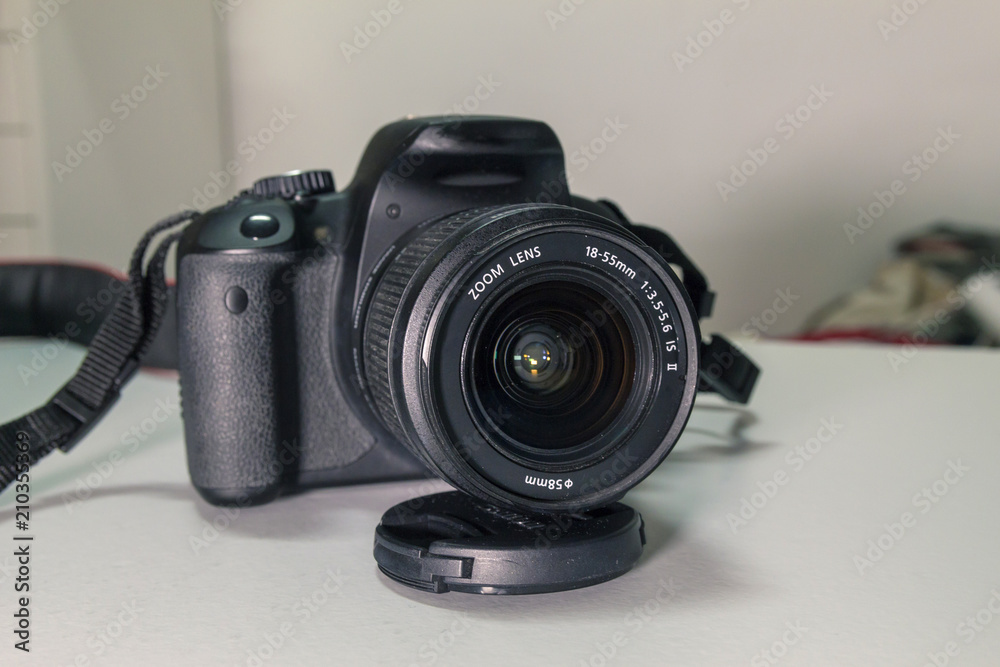 Closeup of modern black DSLR camera on white table