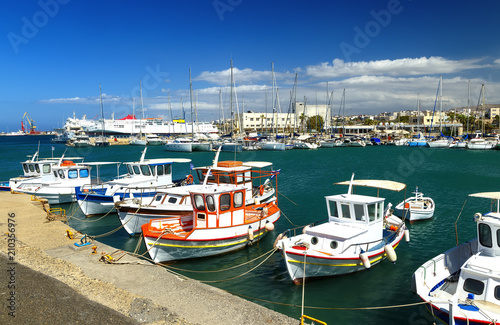 The walk along the harbor of Heraklion with ruins of Venetian era buildings and numerous yachts and boats in port, Crete, Greece.