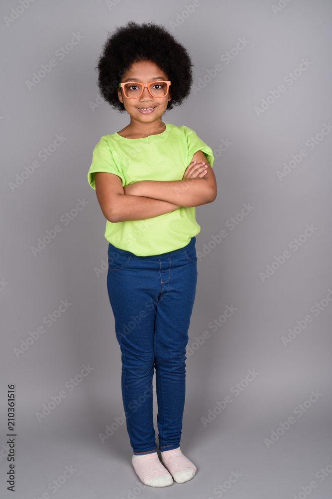 Young cute African girl against gray background