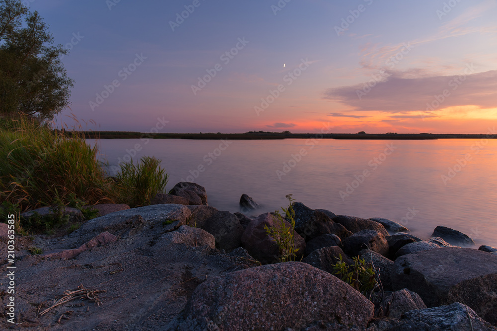 Obraz premium Rocky shore of the sea bay in the quiet evening