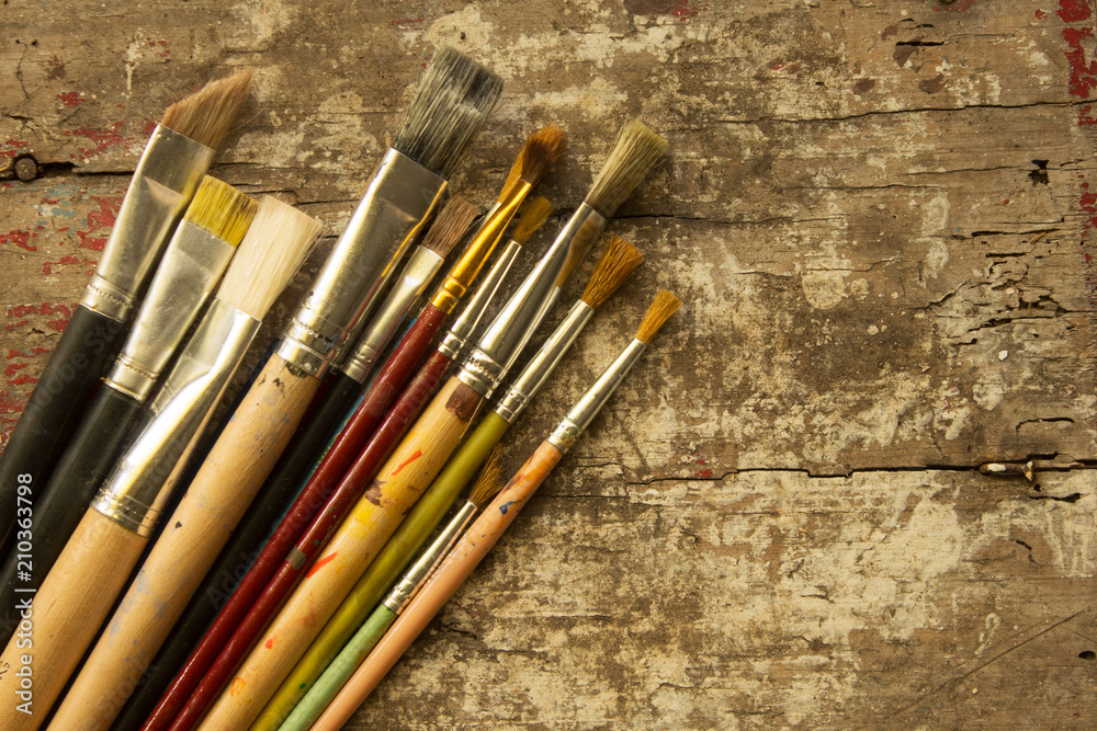 Obraz premium different size of artist paint brushes on a rustic wood table
