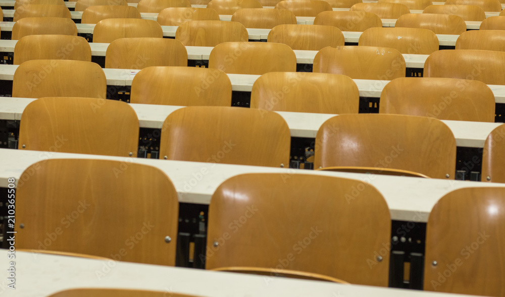 Fototapeta premium Sedie ordinate simmetricamente in aula universitaria. Scuola vuota. Banchi, sedie