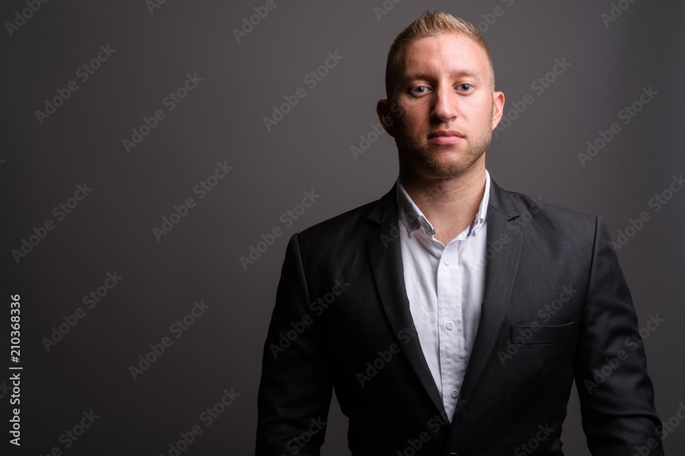 Businessman with blond hair against gray background Businessman with blond hair against gray background