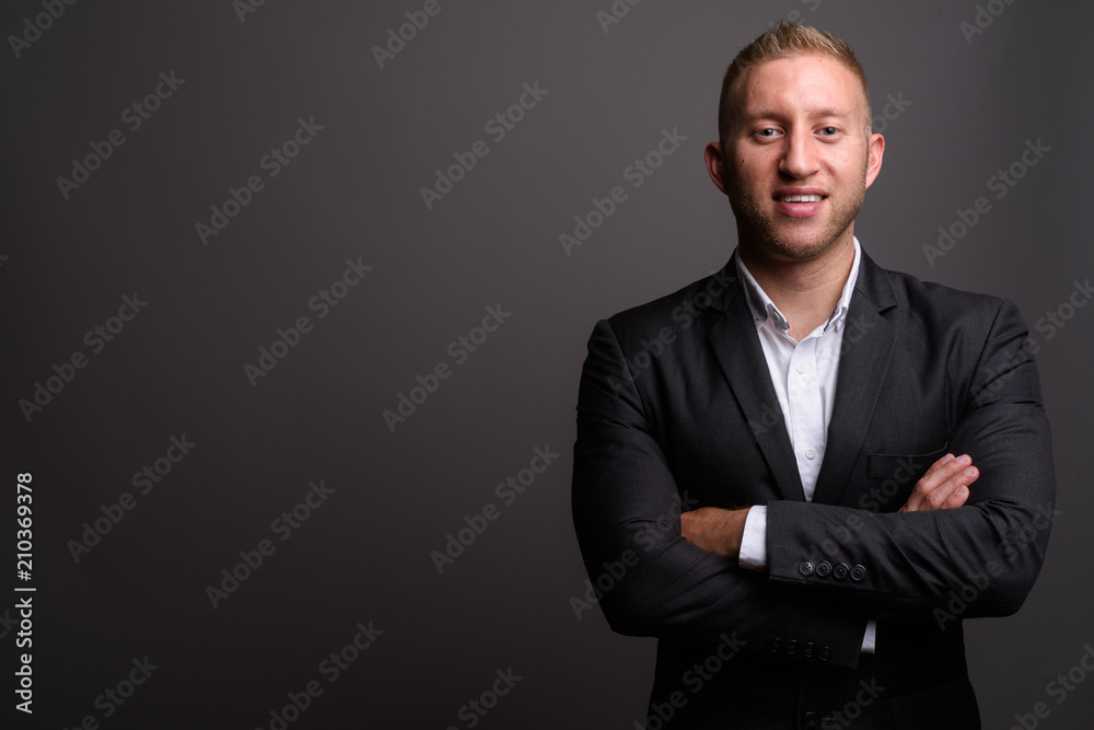 Businessman with blond hair against gray background Businessman with blond hair against gray background