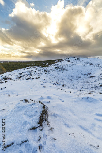 Panoramic view of the Kerid Volcano Iceland with snow and ice in the volcanic crater lake in Winter under a blue sky