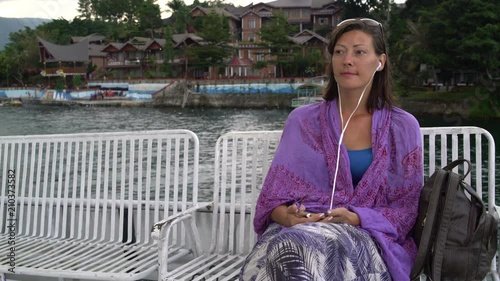 A woman sails on a boat and listens to music on headphones photo