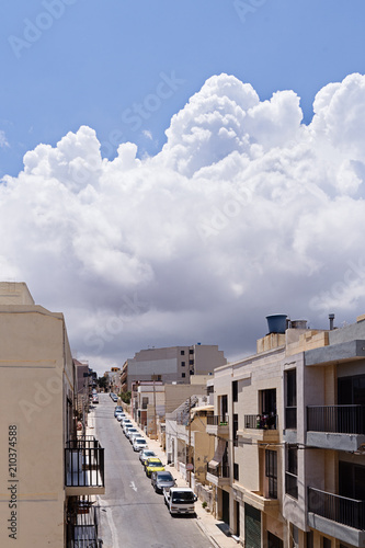 View of typical narrow Maltese street in front of thunder-storm. Large rain clouds hung over the city. photo